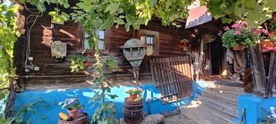 A courtyard corner with a pergola and traditional wooden barrels
