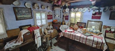 The house-museum room, with icons, painted plates and a festive table