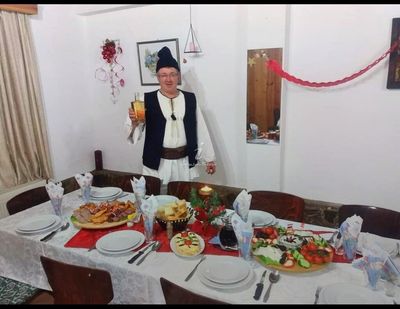 Domnul Ioan, in folk costume, at a festive New Year's dinner