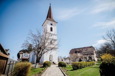 The Holy Trinity Church tower in Sibiel, with the entrance to the Glass Icons Museum beside it