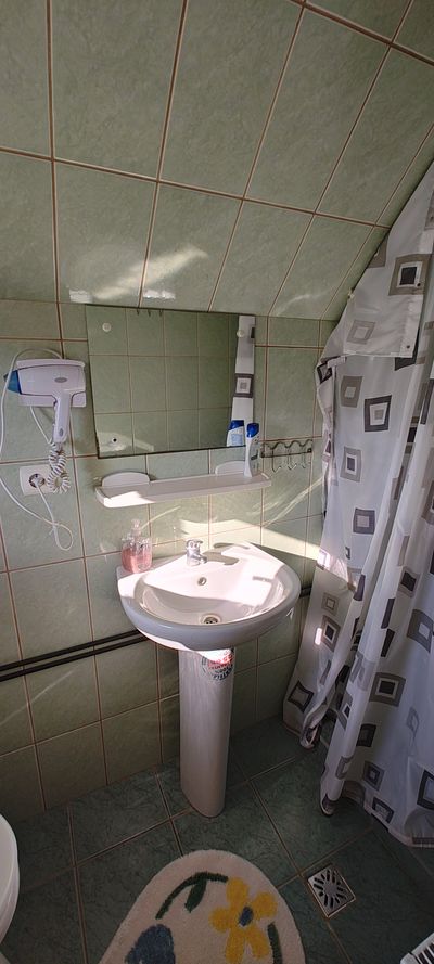 Sink and mirror, in one of the guesthouse bathrooms