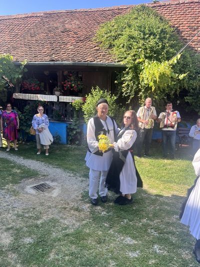 A couple dancing in folk costume, with musicians in the background